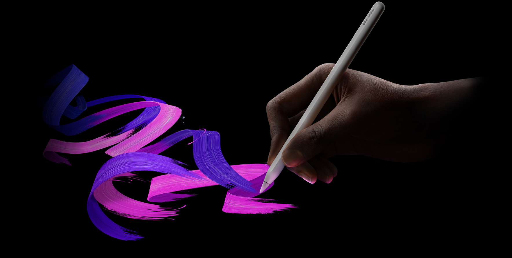 用户手拿 Apple Pencil Pro，做出书写的姿势。几道呈现粉色与紫色交融的弯曲笔触，自然而然地从 Apple Pencil Pro 的笔尖流出。