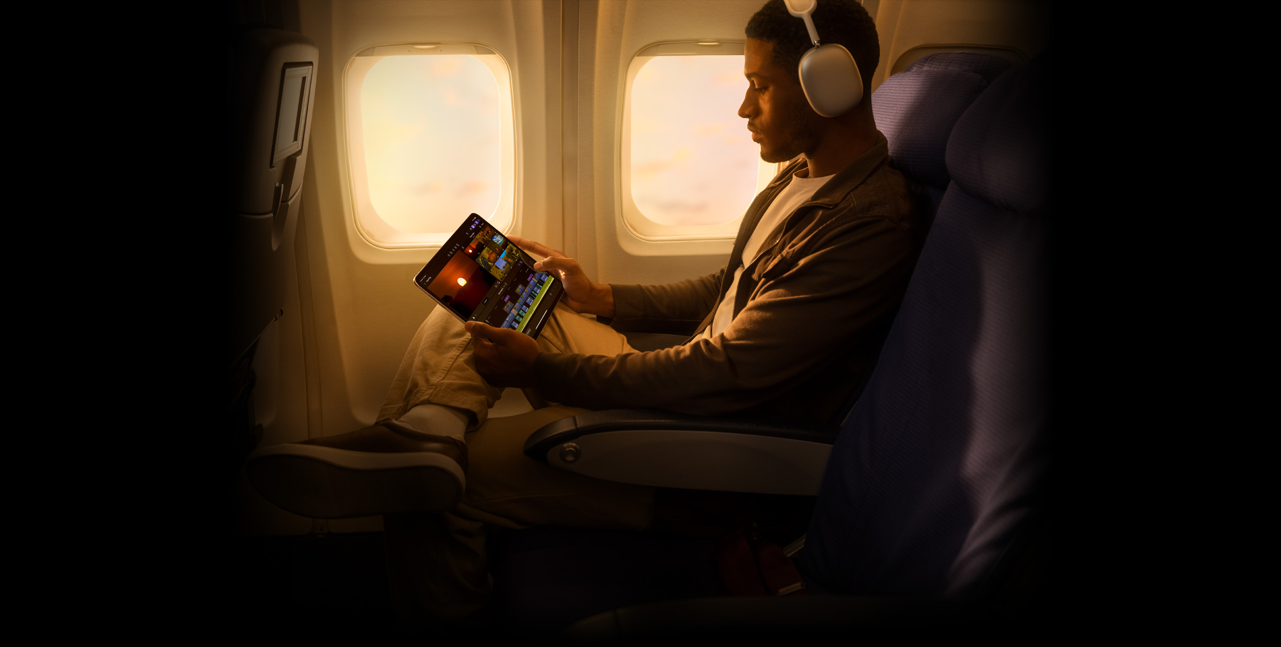 戴着耳机的人在 iPad Pro 上的 iPad 版 Final Cut Pro 中剪辑素材。