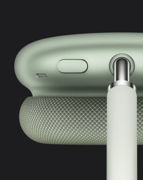 绿色 AirPods Max 耳罩特写，精细展示穹网连接点旁的噪音控制按钮。