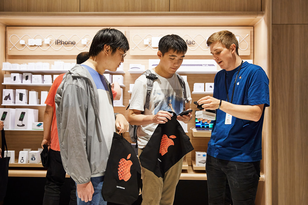 在 Apple Battersea 零售店内，一名 Apple 团队成员协助顾客设置 iPhone 14。
