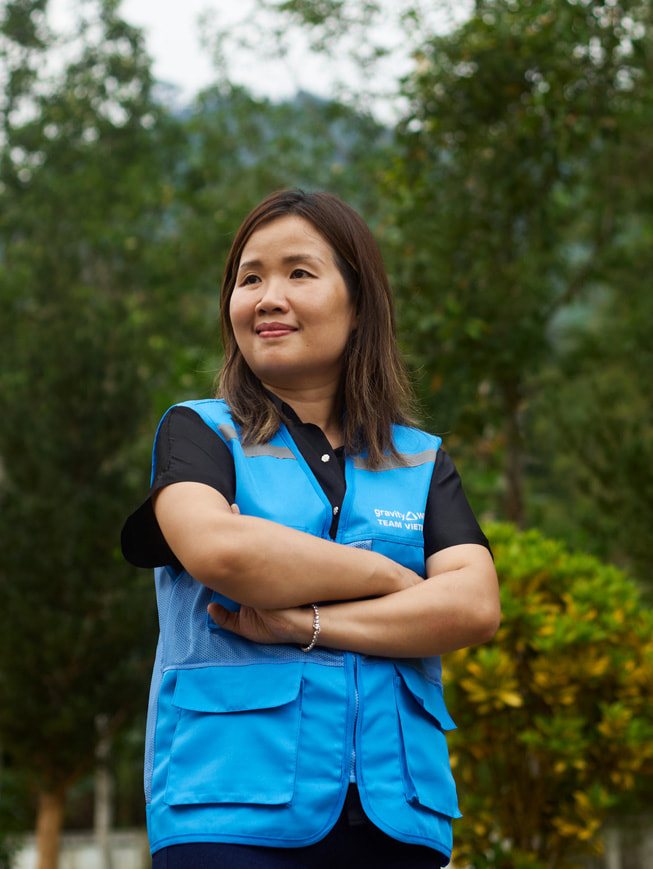 Chu Thanh Hoa 站在户外，身穿蓝色 Gravity Water 马甲。