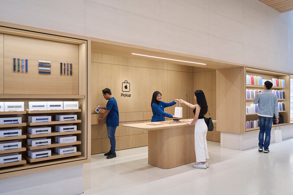 在 Apple The Exchange TRX 零售店内，两名团队成员正在为顾客提供协助。