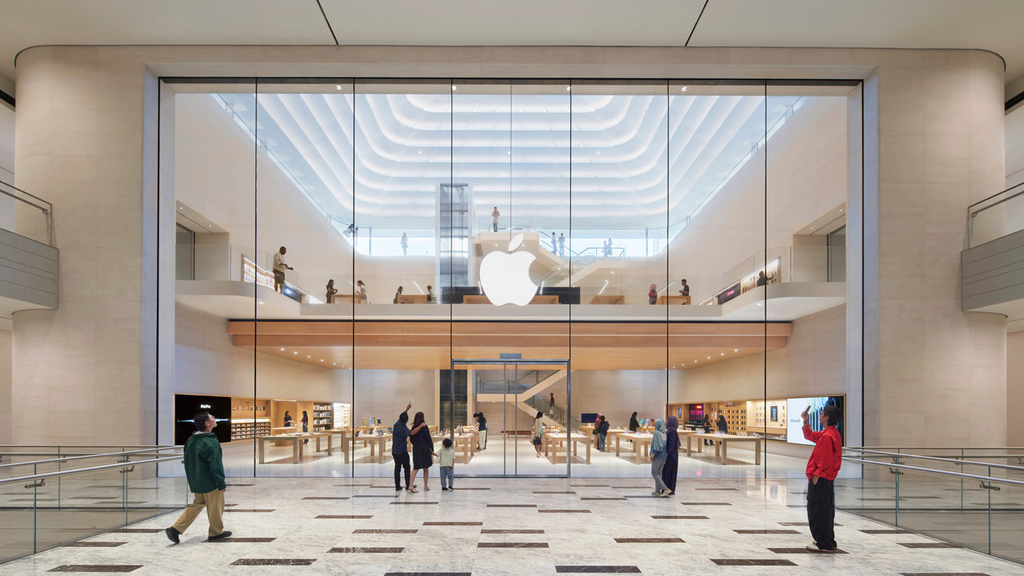 顾客站在 Apple The Exchange TRX 零售店内部入口前的照片。