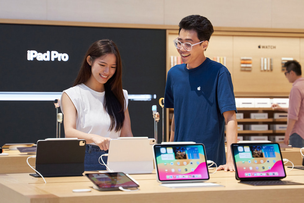 一位顾客和一名团队成员站在店内 iPad 展示桌前。