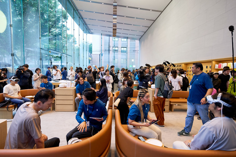 远景照片展示繁忙的 Apple 表参道零售店内有数十位顾客和团队成员。