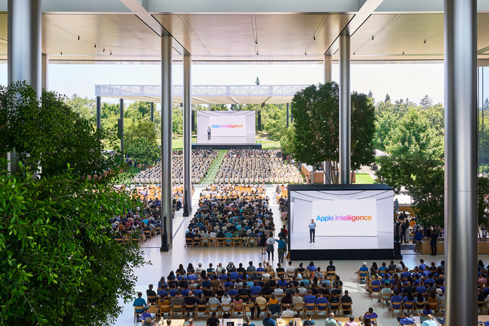 俯拍镜头下正在 Apple Park 的 Caffè Macs 观看大屏幕上主题演讲的开发者。 