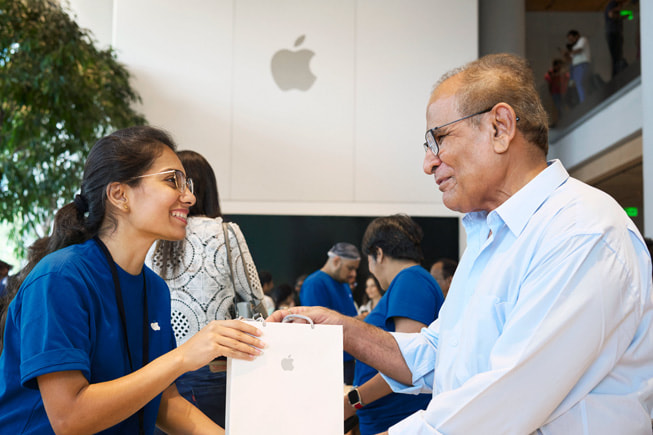 An Apple team member assists a customer with their purchase.