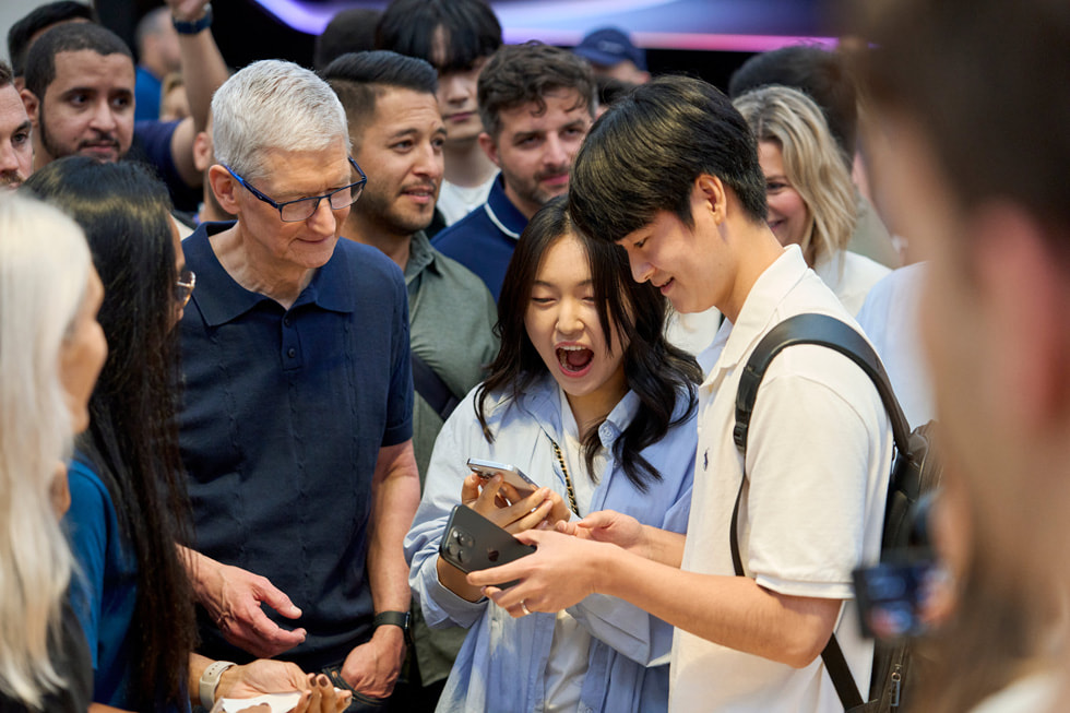 Tim Cook 与纽约 Apple 第五大道零售店的顾客站在一起。