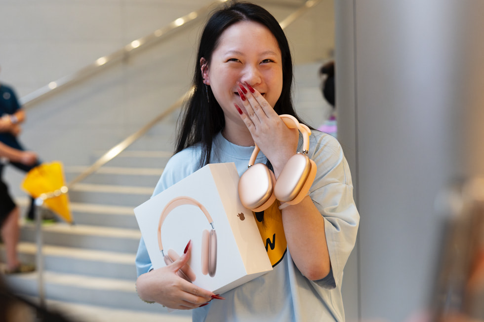 一位顾客腼腆地展示自己新购买的 AirPods Max。