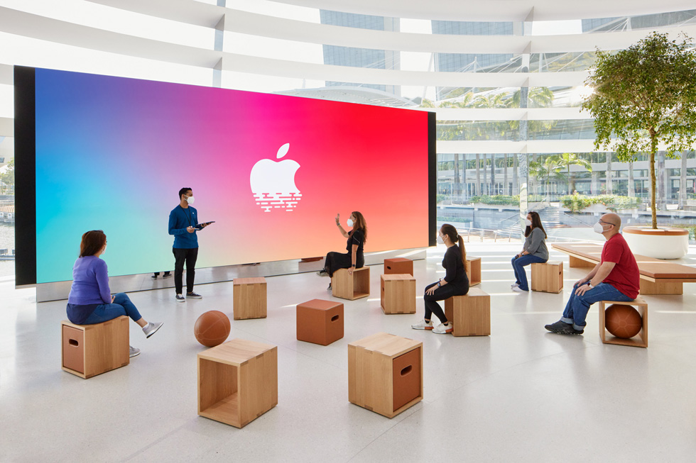 顾客坐下来聆听 Apple 工作人员的讲解。