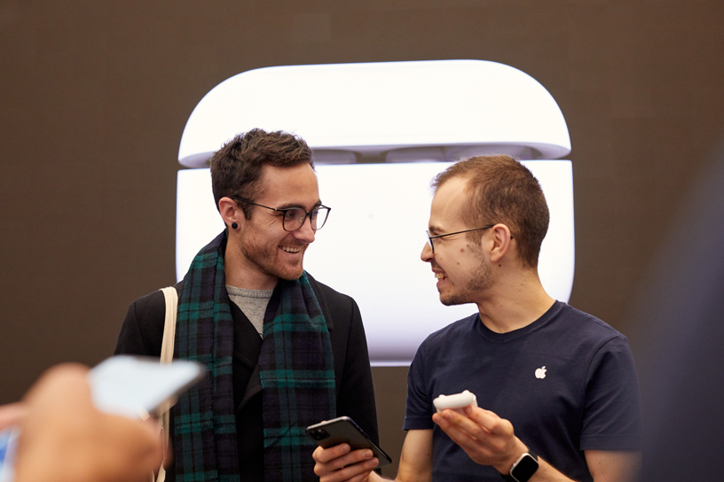 伦敦 Apple Regent Street 店内，一位工作人员协助顾客设置 AirPods Pro。