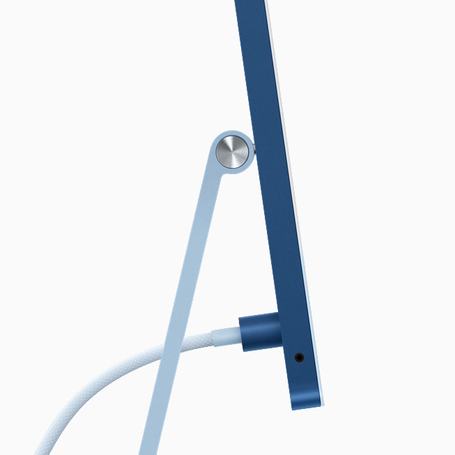 蓝色 iMac 的侧视图，展示电源连接器与同色编织电源线。