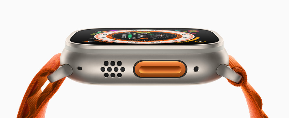Apple Watch Ultra 的侧面照片，展示国际橙色操作按钮与橙色表带。