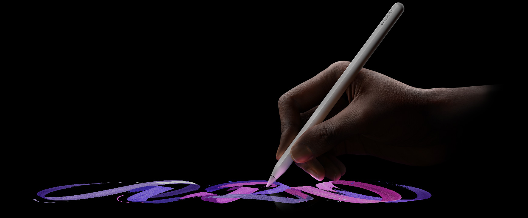 用户手拿 Apple Pencil Pro，做出书写的姿势。几道呈现粉色与紫色交融的弯曲笔触，自然而然地从 Apple Pencil Pro 的笔尖流出。